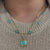 Gold paperclip necklace with a blue turquoise sleeping beauty pendant 
